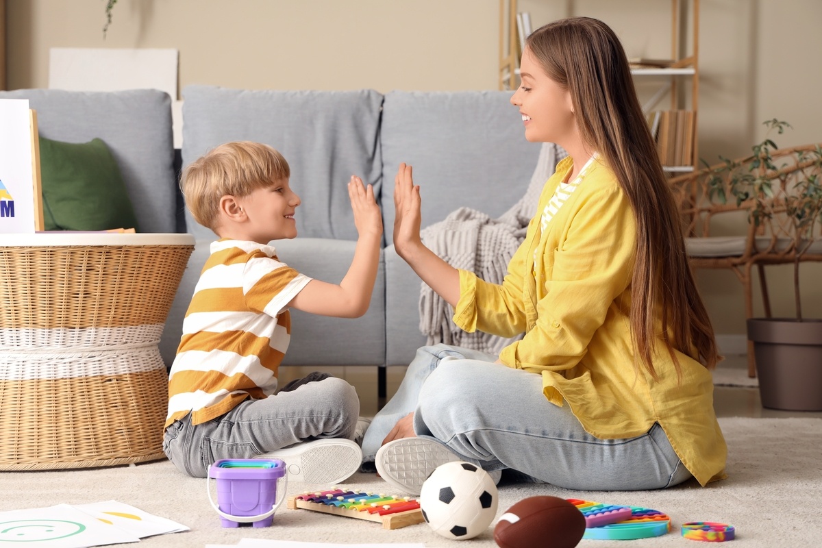 Caregiver providing autism support in Queens during an in-home play therapy session with a child