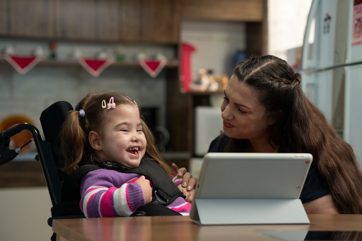 Caregiver helping a young girl in a wheelchair with special needs care in Brooklyn